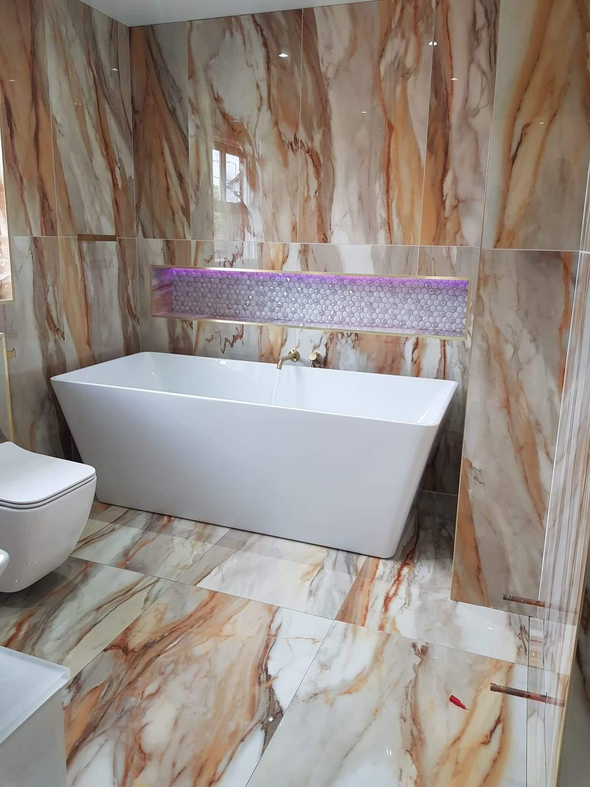 Marble bathroom with freestanding bath and gold fittings