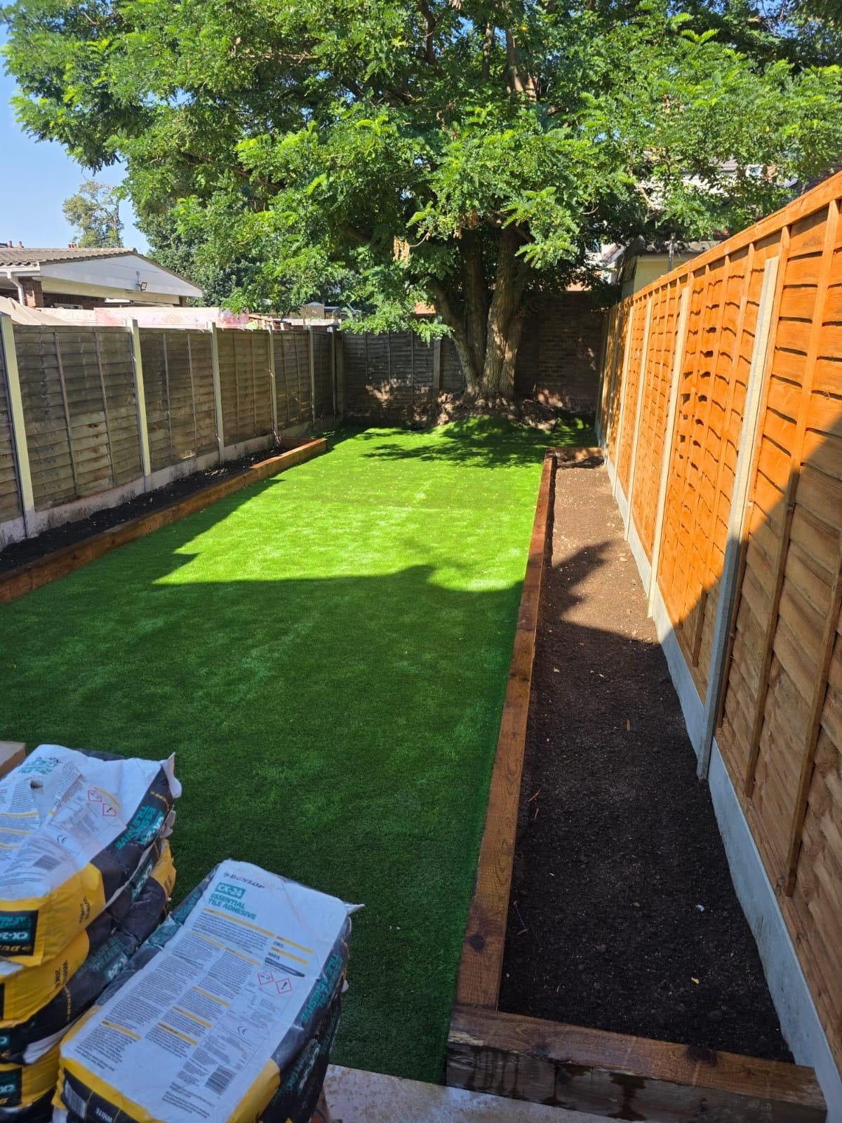 Garden landscaping with artificial lawn and timber raised beds