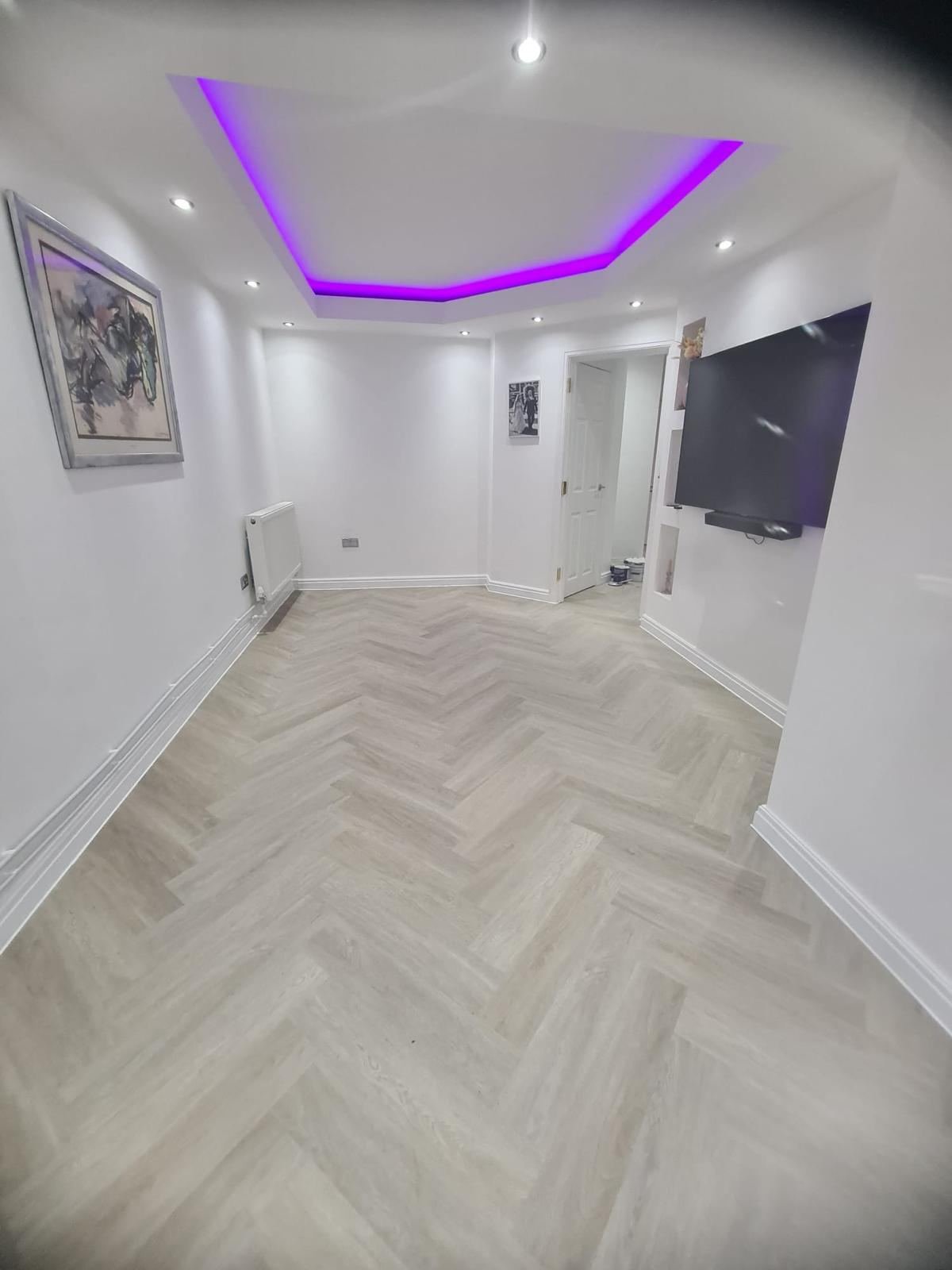 Living room renovation with herringbone flooring and LED ceiling feature