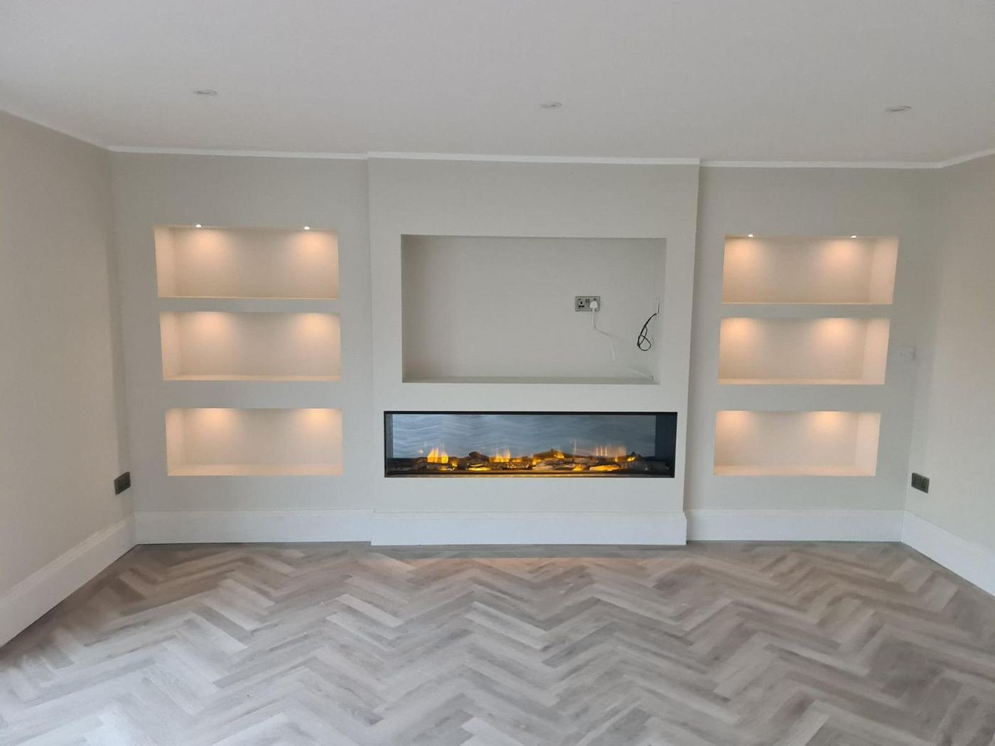 Living room renovation with built-in alcove shelving and feature fireplace